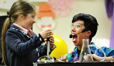 A picture of a scientist with her assistant, they are completing a science experiment.