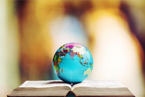 world globe sitting atop book