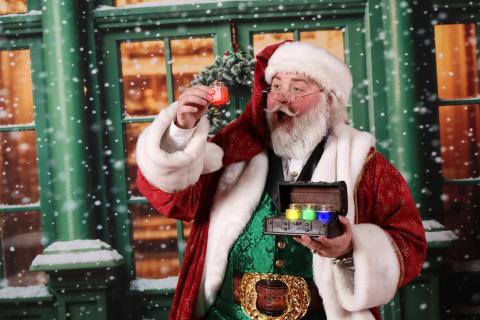 Santa Joey holding up a red jar.